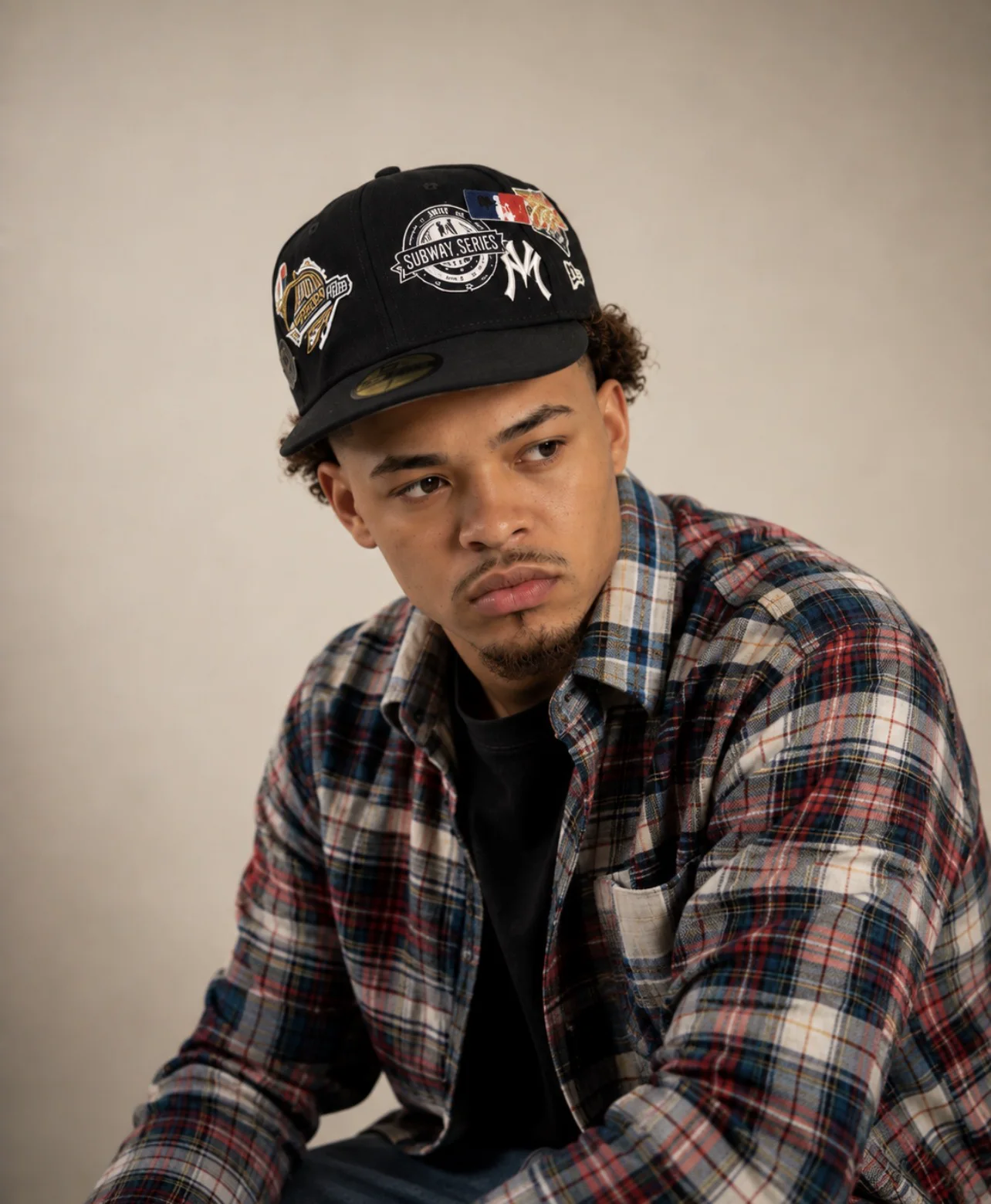 CJ WestCoast in a plaid shirt and cap